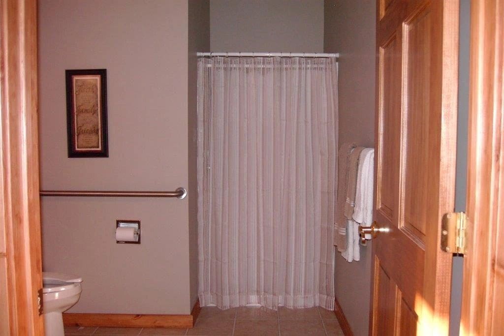 A bathroom with a shower curtain and a towel rack.